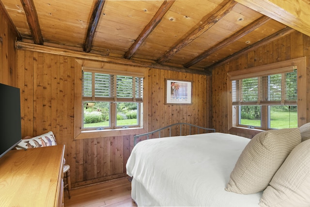 bedroom featuring multiple windows, wood walls, wood ceiling, and vaulted ceiling with beams