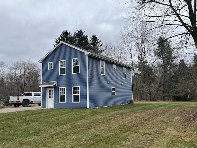 view of side of property with a lawn and central AC