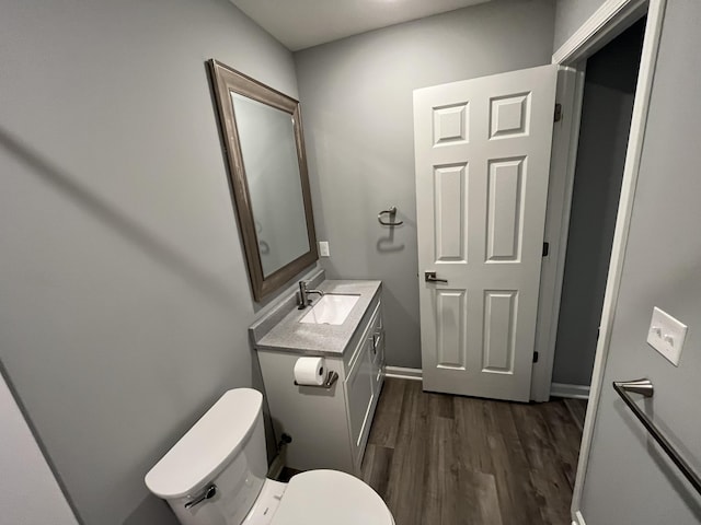 bathroom with hardwood / wood-style flooring, vanity, and toilet