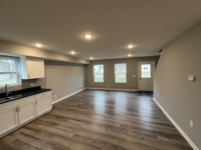 unfurnished living room with dark hardwood / wood-style flooring and sink