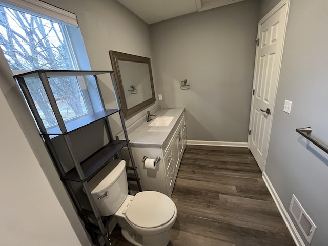 bathroom featuring toilet, vanity, and hardwood / wood-style flooring