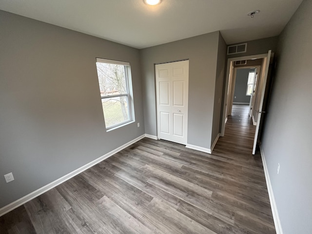 unfurnished bedroom featuring a closet and hardwood / wood-style flooring