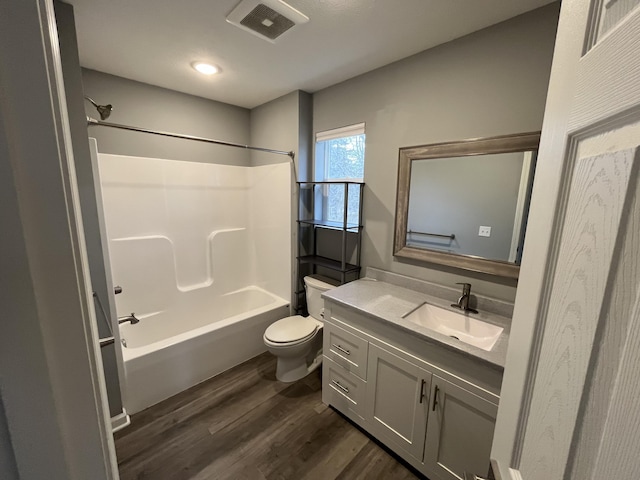 full bathroom with hardwood / wood-style floors, vanity, toilet, and tub / shower combination