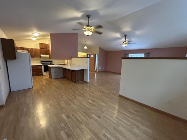 kitchen with lofted ceiling, white appliances, ceiling fan, light wood-type flooring, and kitchen peninsula