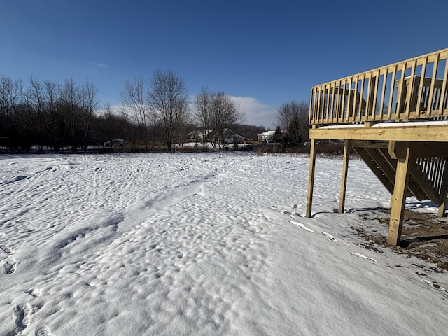 yard covered in snow with a deck