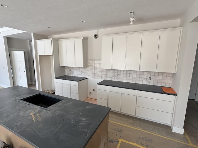 kitchen with white cabinets, decorative backsplash, and a kitchen island