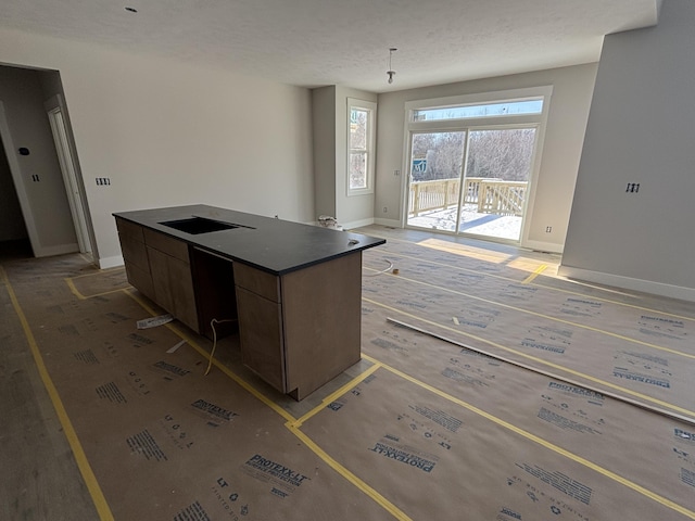 kitchen with cooktop, a center island, and dark brown cabinetry