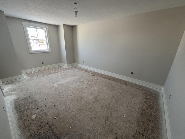 unfurnished room featuring a textured ceiling