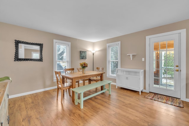 dining area featuring light wood-type flooring and baseboards