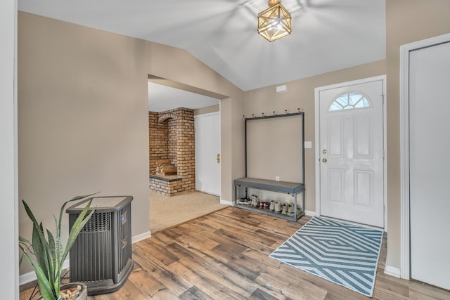 entrance foyer featuring lofted ceiling, baseboards, and wood finished floors