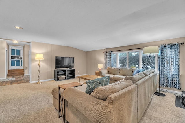 carpeted living area featuring lofted ceiling and baseboards