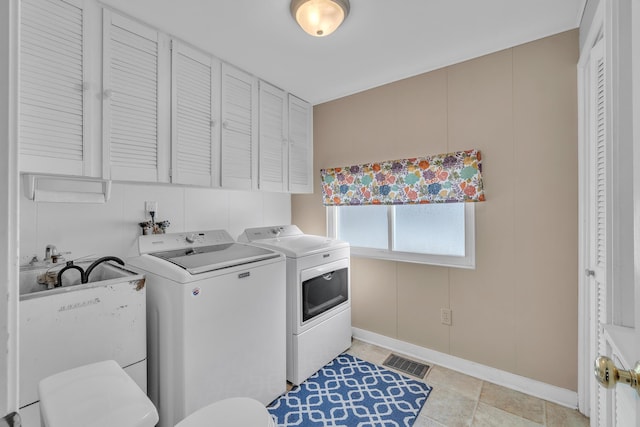 washroom with laundry area, separate washer and dryer, and visible vents