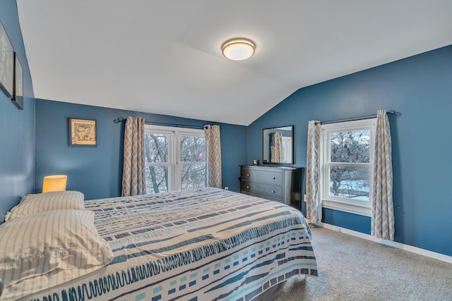 carpeted bedroom with lofted ceiling and baseboards