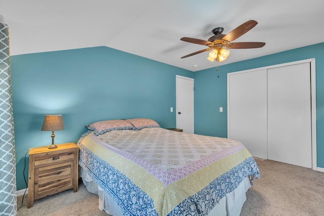 bedroom featuring lofted ceiling, a closet, carpet flooring, and a ceiling fan