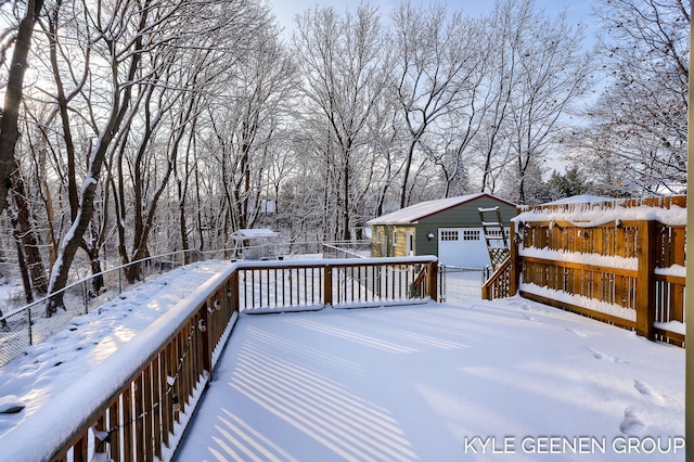 snow covered deck featuring a garage and an outdoor structure