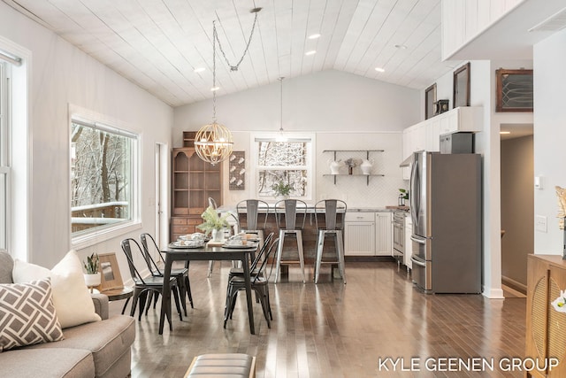 dining area with dark hardwood / wood-style floors, vaulted ceiling, wooden ceiling, and a notable chandelier