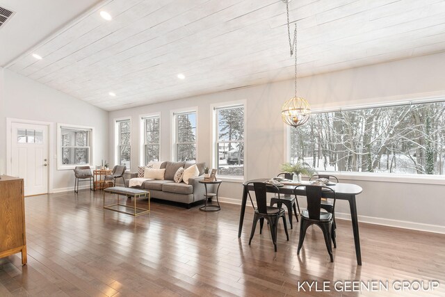 dining room featuring lofted ceiling, hardwood / wood-style flooring, an inviting chandelier, and wooden ceiling