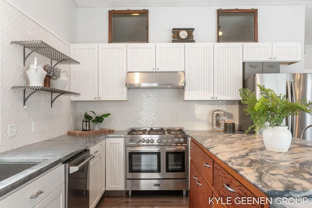 kitchen with appliances with stainless steel finishes, backsplash, and white cabinetry