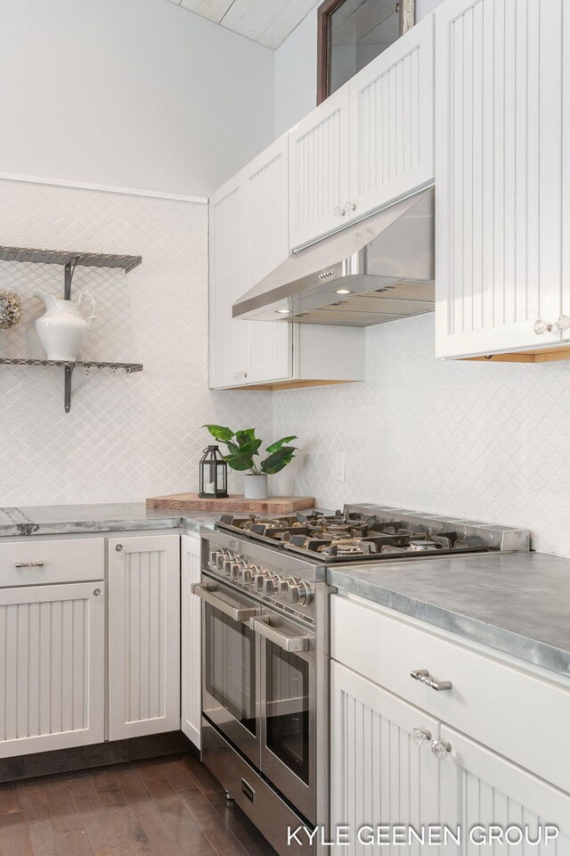 kitchen featuring white cabinets, decorative backsplash, range with two ovens, and dark wood-type flooring