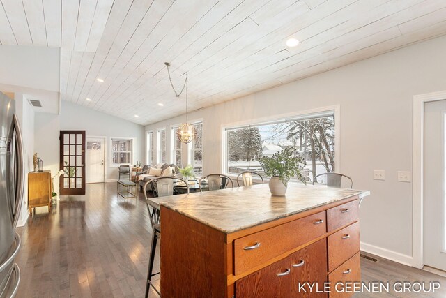 kitchen with decorative light fixtures, a kitchen island, wooden ceiling, and stainless steel refrigerator