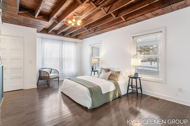 bedroom featuring dark wood-type flooring, beamed ceiling, wood ceiling, and an inviting chandelier