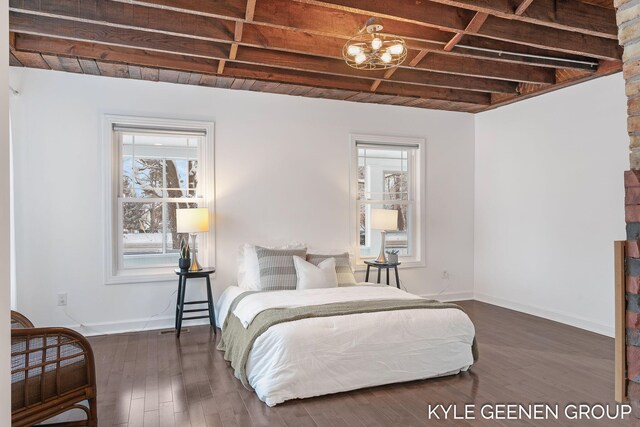 bedroom with beamed ceiling and dark wood-type flooring