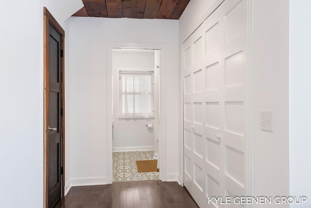 corridor with dark hardwood / wood-style flooring and wooden ceiling