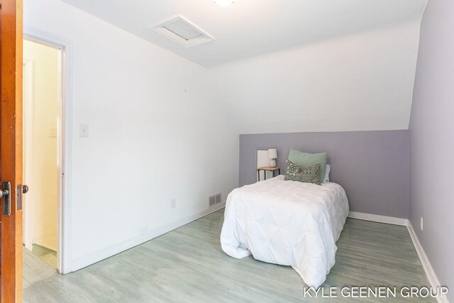 bedroom featuring wood-type flooring and vaulted ceiling