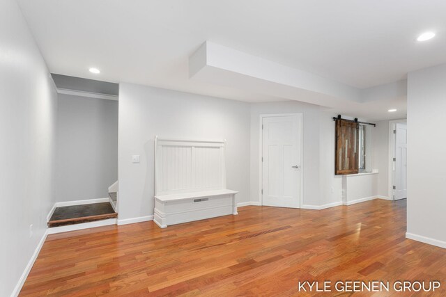 unfurnished room featuring a barn door and light hardwood / wood-style floors