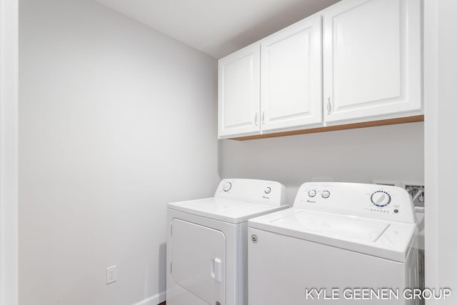 clothes washing area featuring washer and clothes dryer and cabinets