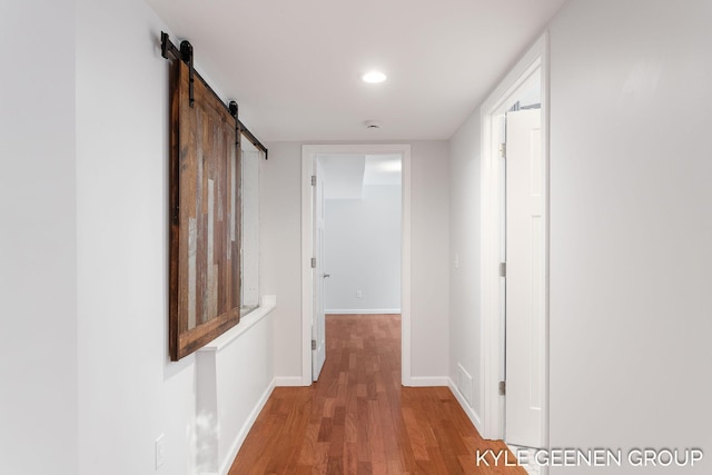 hallway featuring hardwood / wood-style flooring and a barn door