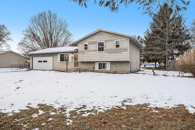 view of front of property featuring a garage and fence