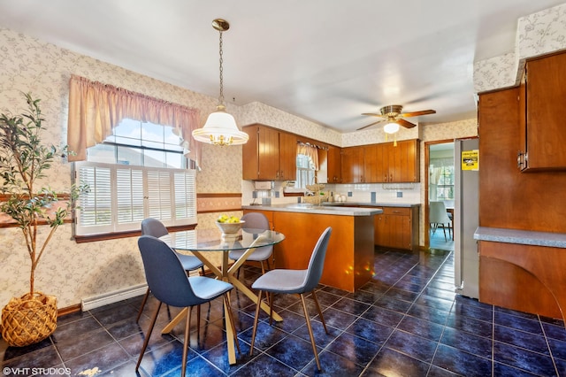 884 Oakridge Dr, Saint Joseph, MI 49085 - kitchen featuring wallpapered walls, a peninsula, brown cabinetry, and plenty of natural light