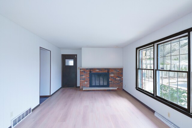 884 Oakridge Dr, Saint Joseph, MI 49085 - unfurnished living room with a fireplace, visible vents, a healthy amount of sunlight, and light wood-type flooring