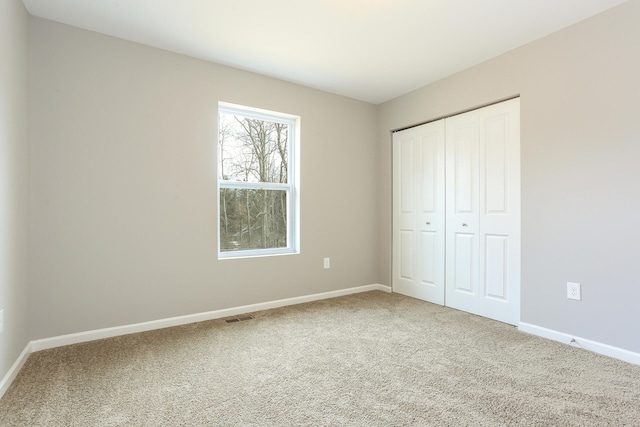 unfurnished bedroom with carpet and a closet