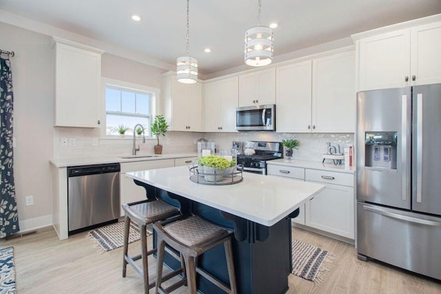 kitchen with a center island, white cabinets, and stainless steel appliances