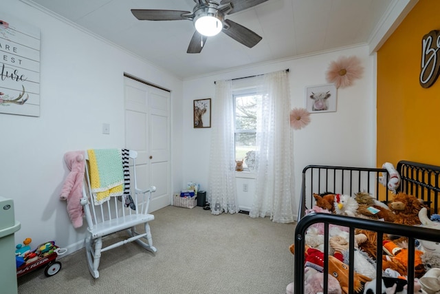 carpeted bedroom featuring ceiling fan, crown molding, and a closet