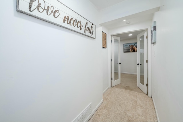 hallway with french doors and light colored carpet