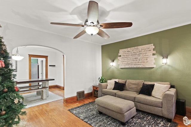 living room with hardwood / wood-style flooring, ceiling fan, and crown molding