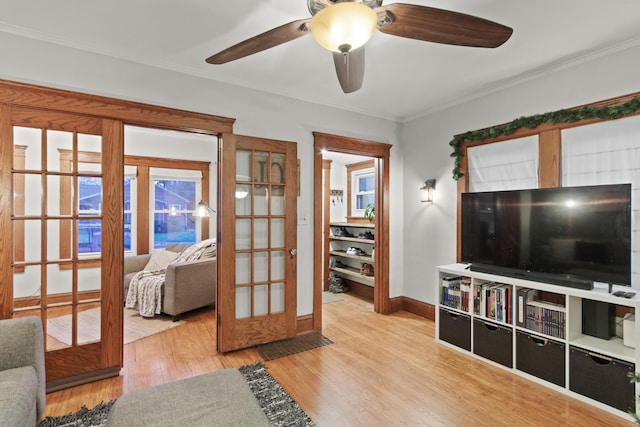 living room with french doors, light hardwood / wood-style floors, and crown molding