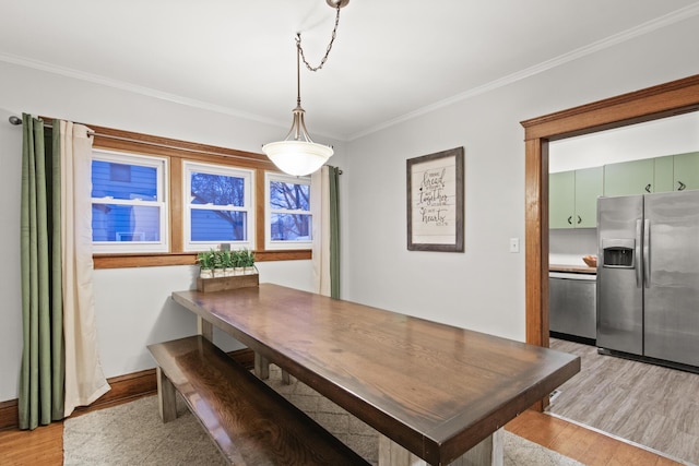 dining space with light hardwood / wood-style flooring and ornamental molding