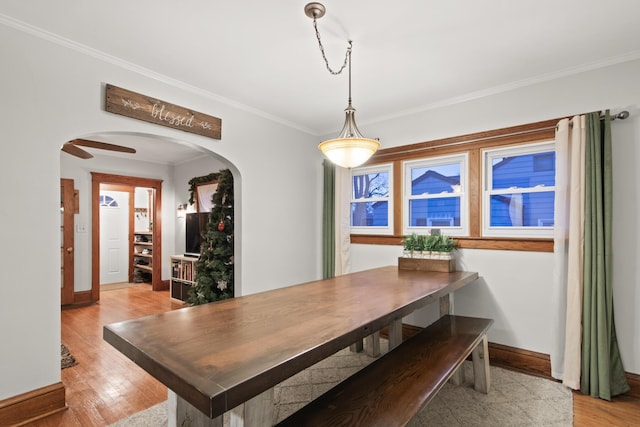 dining space featuring light wood-type flooring and crown molding