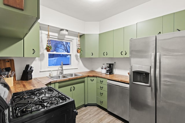 kitchen with butcher block counters, green cabinets, and stainless steel appliances