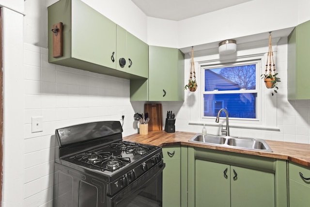 kitchen featuring wood counters, decorative backsplash, sink, black gas stove, and green cabinets