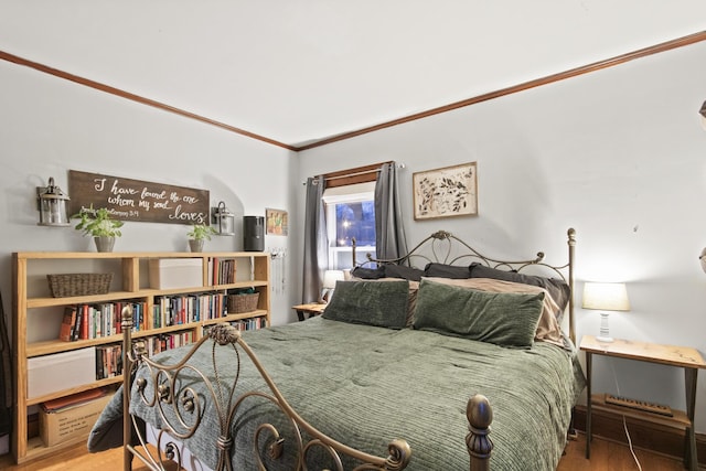 bedroom with hardwood / wood-style floors and crown molding