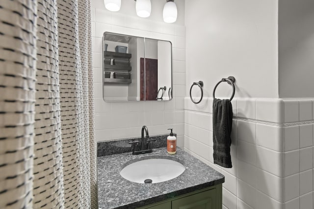 bathroom featuring vanity and tile walls