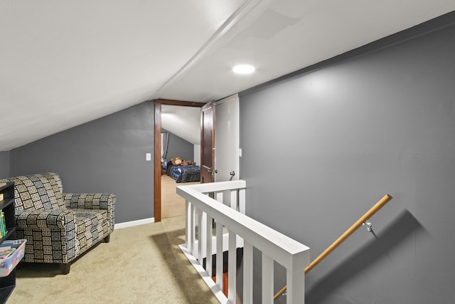 hall with carpet flooring and vaulted ceiling