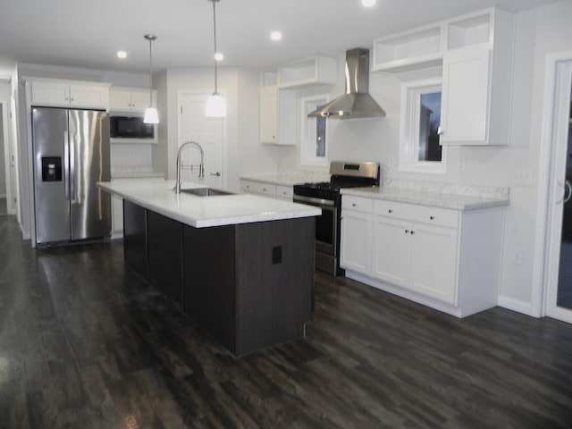 kitchen with sink, dark wood-type flooring, wall chimney range hood, decorative light fixtures, and appliances with stainless steel finishes