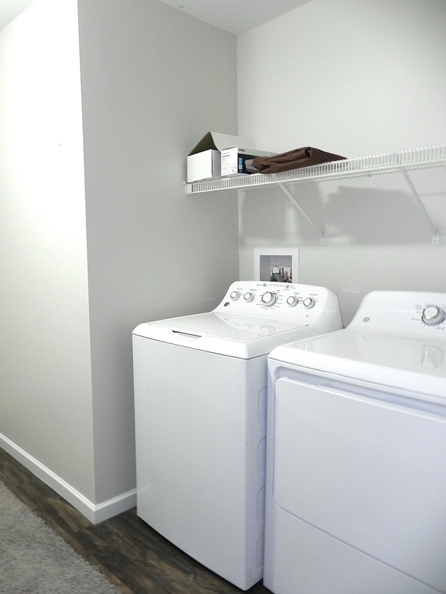 washroom with dark hardwood / wood-style flooring and washer and clothes dryer