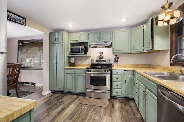 kitchen with green cabinets, sink, dark hardwood / wood-style floors, and appliances with stainless steel finishes